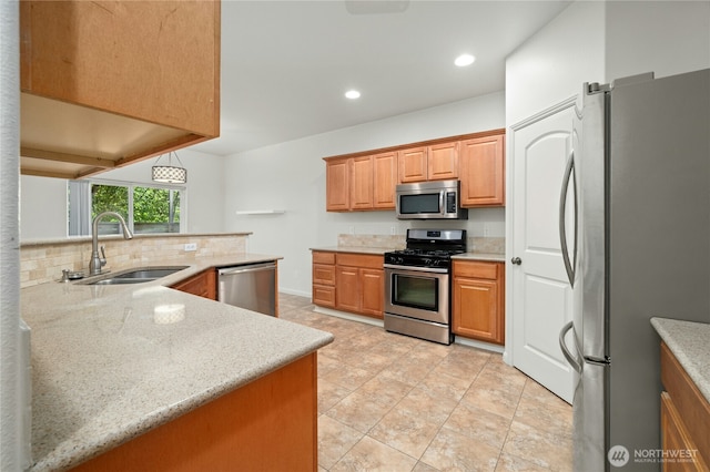 18910 SE 41st Dr, Vancouver, WA 98683 - kitchen featuring appliances with stainless steel finishes, a sink, decorative backsplash, recessed lighting, and light stone countertops