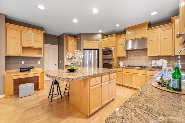 908 274th Way SE, Sammamish, WA 98075 - kitchen with stainless steel appliances, under cabinet range hood, light brown cabinetry, a kitchen island, and light wood-style flooring