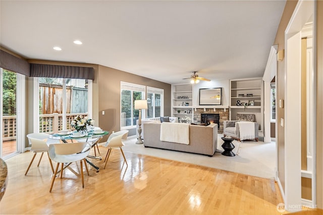 908 274th Way SE, Sammamish, WA 98075 - living area featuring ceiling fan, a glass covered fireplace, light wood-style flooring, recessed lighting, and built in shelves