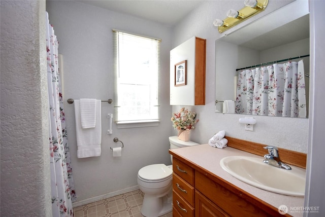 bathroom featuring plenty of natural light, toilet, vanity, and tile patterned floors
