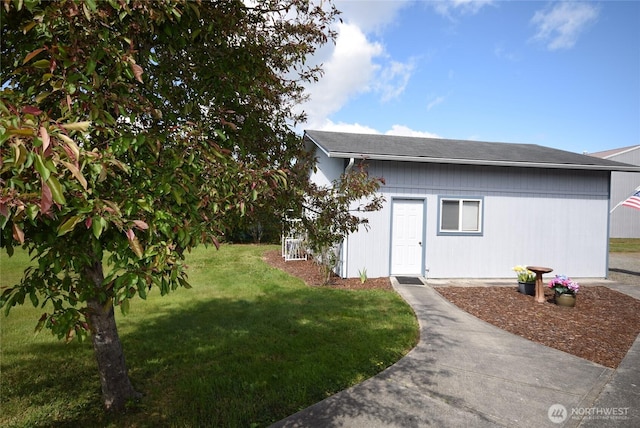 view of front of home featuring a front lawn and an outbuilding