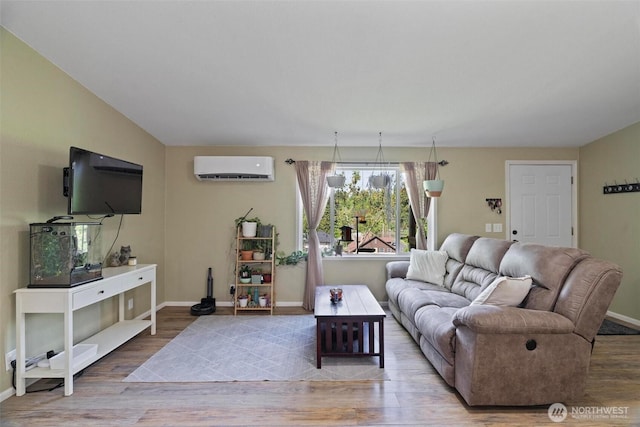 living room with a wall mounted air conditioner, baseboards, and wood finished floors