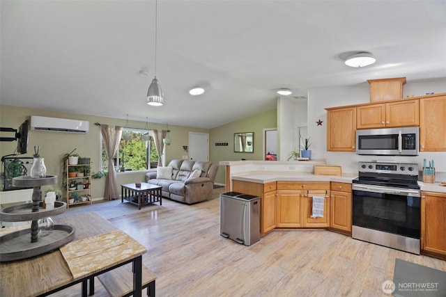 kitchen with appliances with stainless steel finishes, open floor plan, light countertops, a peninsula, and vaulted ceiling