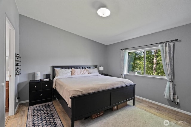 bedroom with wood finished floors and baseboards
