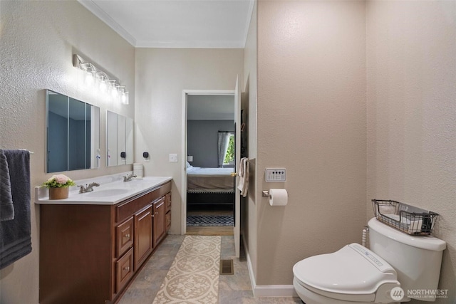 ensuite bathroom featuring toilet, double vanity, and stone finish floors