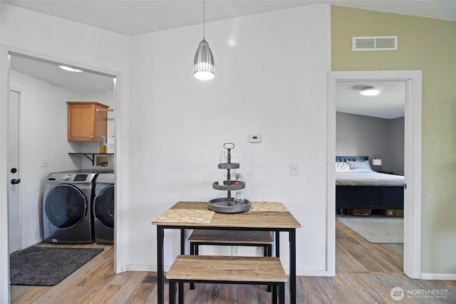 dining area featuring separate washer and dryer, light wood-style flooring, and baseboards