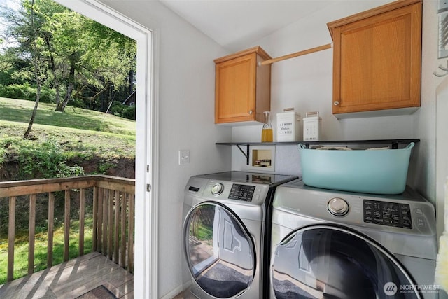 washroom with washing machine and clothes dryer and cabinet space