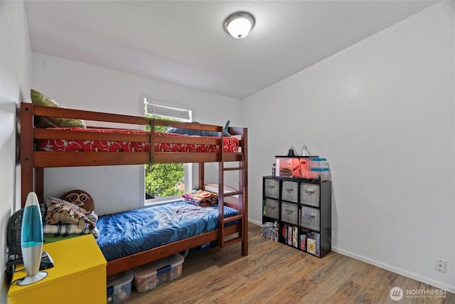 bedroom with wood finished floors and baseboards