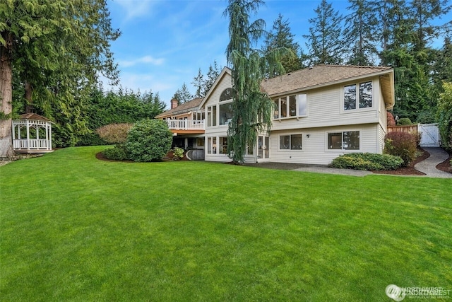 9416 NE 25th St, Clyde Hill, WA 98004 - rear view of property featuring a yard, a chimney, and a wooden deck