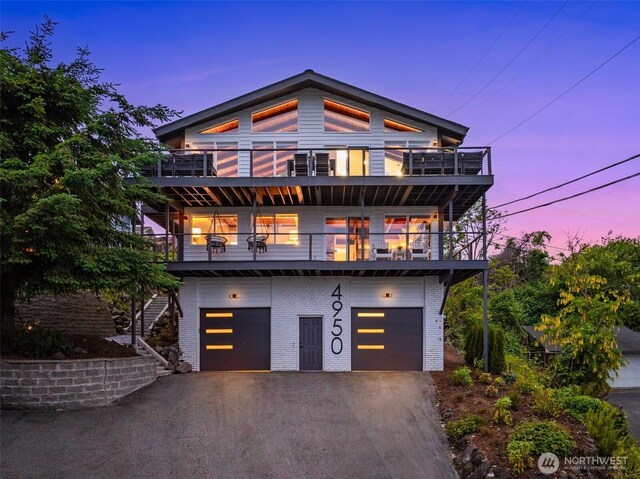 4950 N Lexington St, Tacoma, WA 98407 - contemporary house featuring a balcony, driveway, an attached garage, and brick siding
