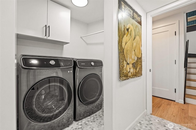 4950 N Lexington St, Tacoma, WA 98407 - washroom featuring washing machine and dryer, baseboards, wood finished floors, and cabinet space