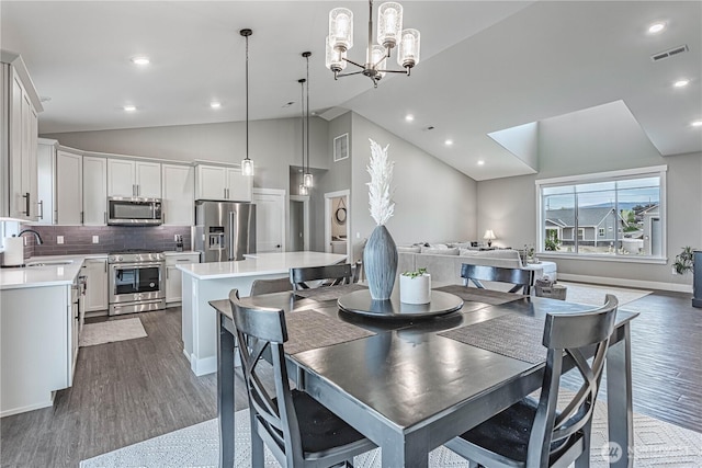 819 N Newport Loop, East Wenatchee, WA 98802 - dining space with vaulted ceiling, dark wood-type flooring, a chandelier, baseboards, and recessed lighting