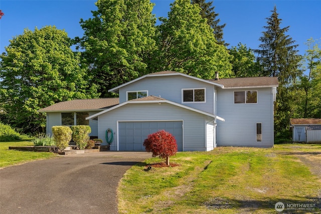 tri-level home featuring driveway, a front lawn, and roof with shingles