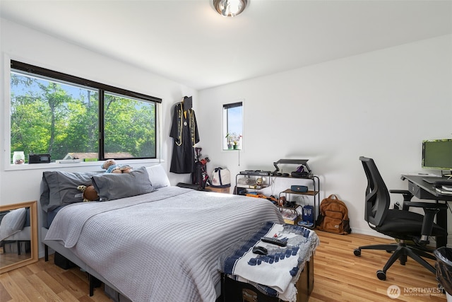 bedroom featuring wood finished floors and a desk
