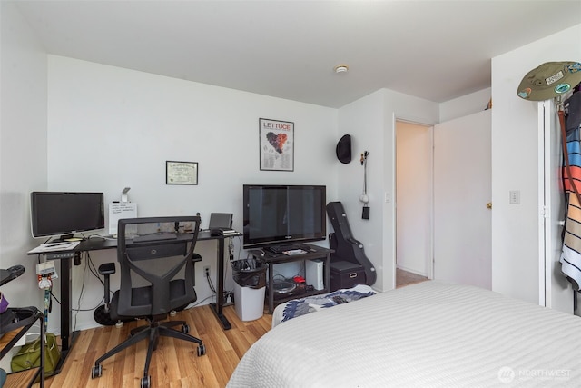 bedroom with wood finished floors and a desk