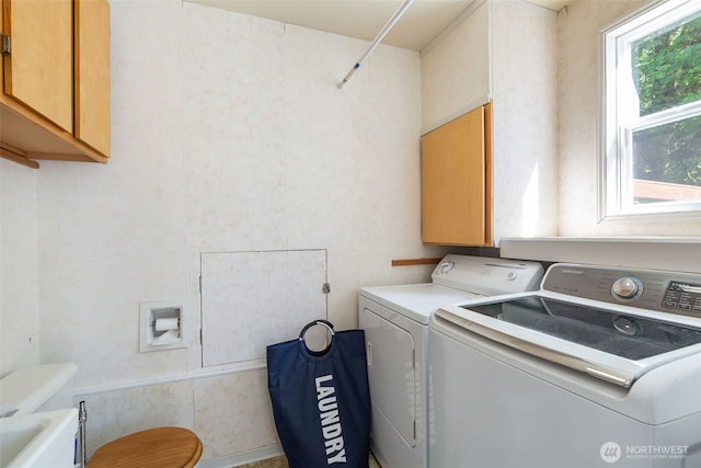 laundry area featuring washer and clothes dryer and cabinet space
