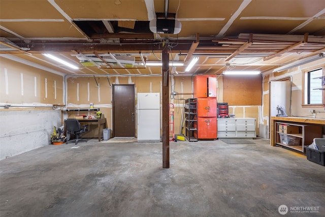 garage with freestanding refrigerator, a garage door opener, and a workshop area