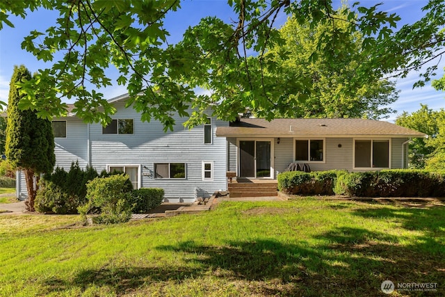 rear view of house featuring a yard