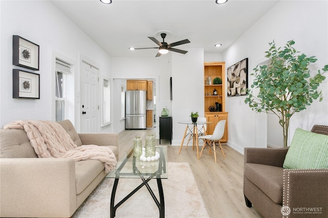 living area featuring light wood-type flooring, recessed lighting, a ceiling fan, and baseboards