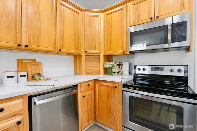 kitchen with appliances with stainless steel finishes and light stone counters