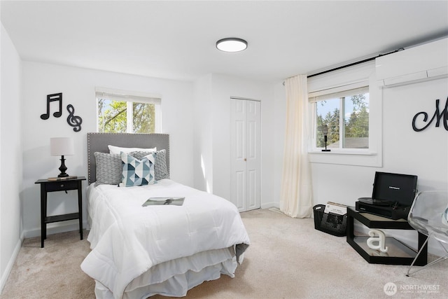 bedroom featuring light colored carpet, a closet, and baseboards