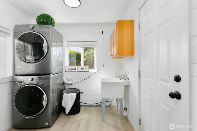 laundry room with stacked washer / dryer, wood finished floors, and ornamental molding