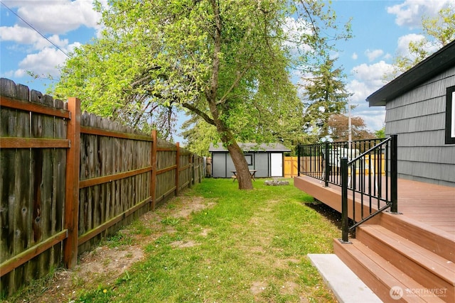 view of yard with a shed, a deck, and an outbuilding