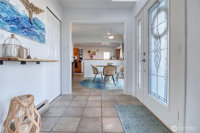 entrance foyer featuring light tile patterned floors, a ceiling fan, and baseboards