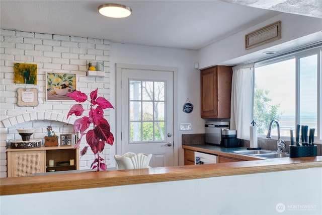 kitchen with a sink, brown cabinets, and dishwasher