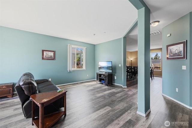 living area with plenty of natural light, wood finished floors, and baseboards