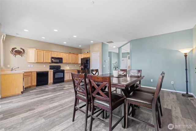dining area with light wood-type flooring, recessed lighting, and baseboards