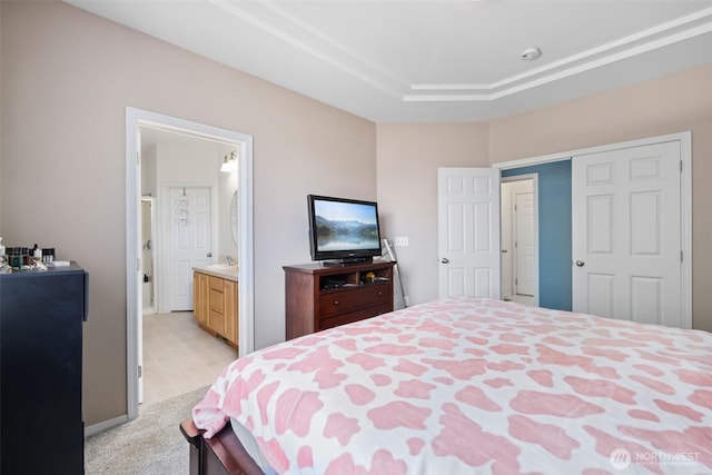 bedroom featuring light colored carpet and ensuite bath