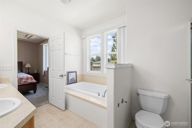 bathroom featuring ensuite bath, a garden tub, double vanity, and toilet