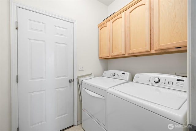 clothes washing area featuring washer and clothes dryer and cabinet space