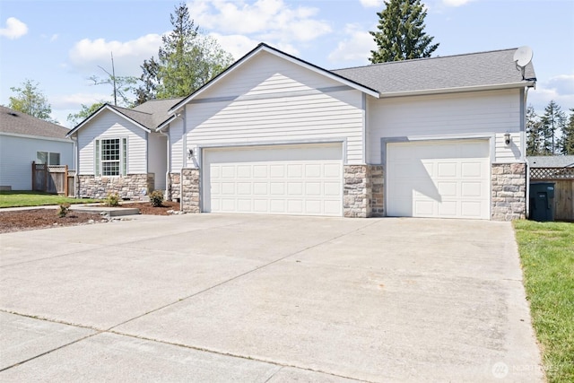 single story home with stone siding, an attached garage, and concrete driveway