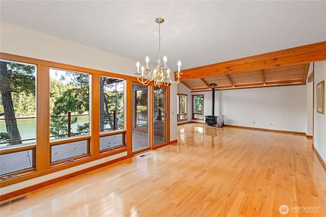 244 Davison Head Dr, Friday Harbor, WA 98250 - empty room featuring a chandelier, wood finished floors, a wood stove, and baseboards