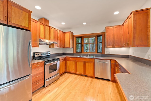 244 Davison Head Dr, Friday Harbor, WA 98250 - kitchen featuring appliances with stainless steel finishes, under cabinet range hood, a sink, light wood-style flooring, and brown cabinetry