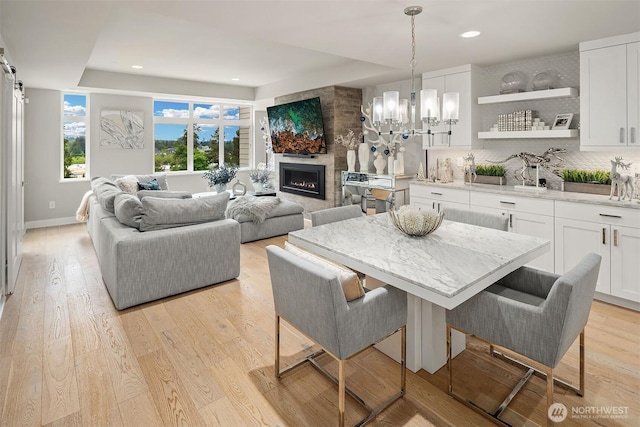 4012 129th Pl SE Unit 2, Bellevue, WA 98006 - living area featuring light wood-type flooring, recessed lighting, a chandelier, a fireplace, and baseboards