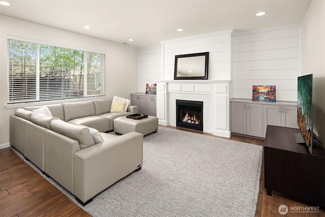 living room featuring dark wood finished floors, recessed lighting, and a fireplace with flush hearth