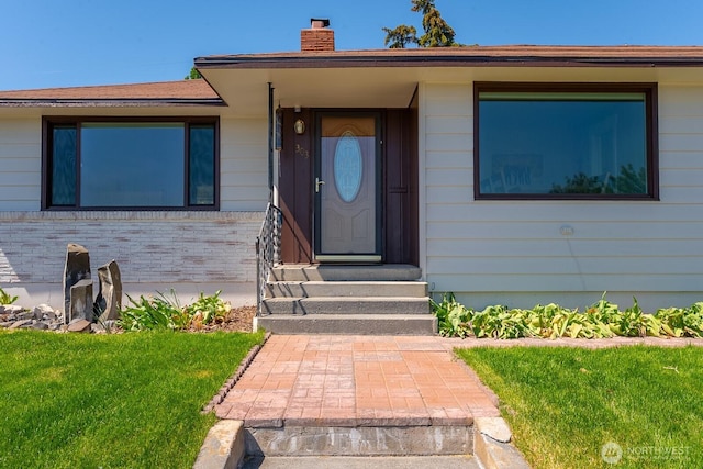 303 Patrick Rd, Ephrata, WA 98823 - property entrance featuring a chimney, a yard, and brick siding