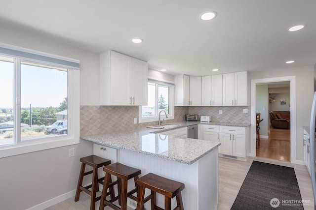 303 Patrick Rd, Ephrata, WA 98823 - kitchen with a sink, a peninsula, white cabinets, a breakfast bar area, and recessed lighting