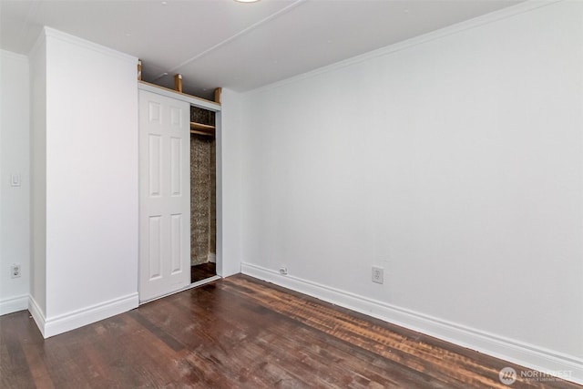 unfurnished bedroom with dark wood-type flooring, baseboards, and a closet