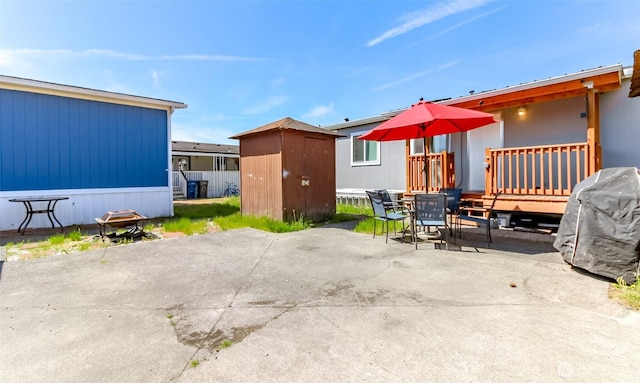 view of patio / terrace featuring a shed, an outbuilding, outdoor dining area, and a deck