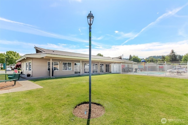 back of house with a community pool and a patio