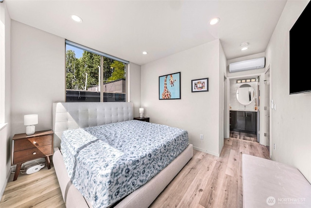 bedroom with a wall unit AC, light wood-style flooring, recessed lighting, and baseboards