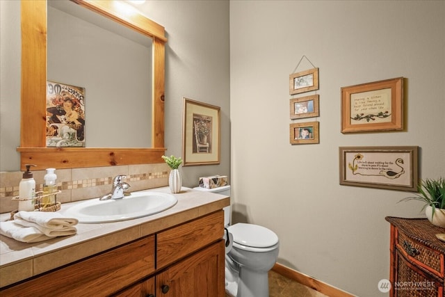 12800 NE Salmon Creek Ave Unit 118, Vancouver, WA 98686 - bathroom featuring vanity, toilet, decorative backsplash, and baseboards