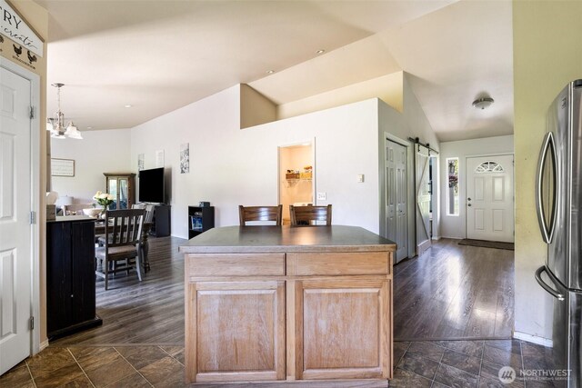 138 Bruinview Ln, Chehalis, WA 98532 - kitchen with freestanding refrigerator, a barn door, dark countertops, light brown cabinetry, and dark stone finish flooring
