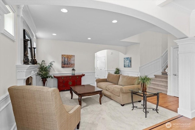 27546 254th Way SE, Maple Valley, WA 98038 - living room with arched walkways, a decorative wall, stairs, wainscoting, and ornamental molding