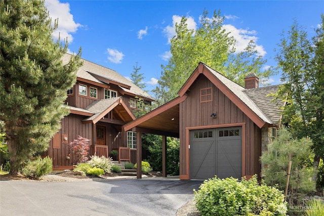 221 Cake Box Ln, Cle Elum, WA 98922 - chalet / cabin with a shingled roof, a chimney, board and batten siding, and driveway