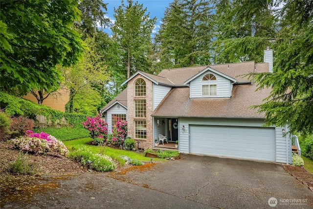 1117 W Racine St, Bellingham, WA 98229 - traditional-style house featuring asphalt driveway, a garage, a chimney, and a shingled roof